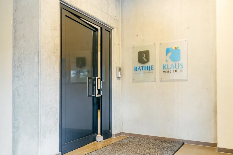 Eingangstür des Hamburger Büros mit dem Schild von Klaus versichert an der Wand